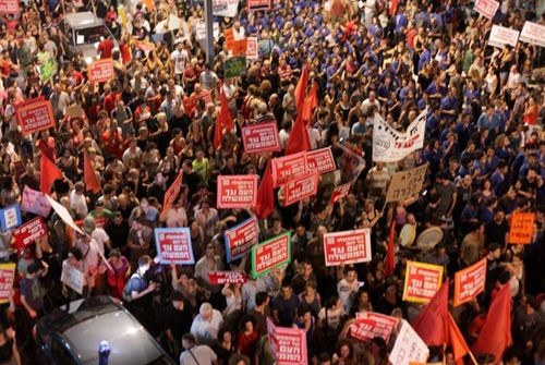 Hadash activists carrying red flags and red banners during the massive Israeli social protest, July 2011