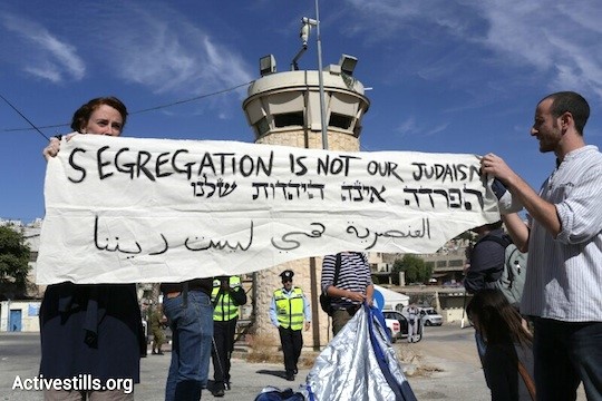 Activists hold a sign reading "Segregation is not our Judaism", Hebron , October 25, 2013 (Photo: Activestills)