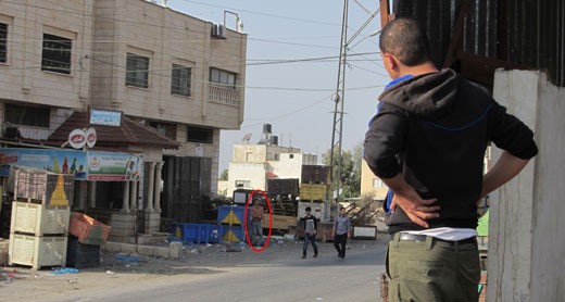 November 5, 2013, Qabatiya market. The man in the right foreground is standing at the spot where Ahmad Tazaz’ah was hit. Across the road, further in the background, the man in the orange shirt is standing where the soldiers were stationed (Photo: B'tselem)