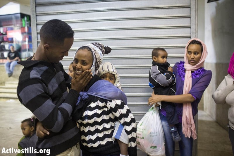 An Eritrean refugee hugs his wife and children, as they arrive to the central bus station in Tel Aviv on May 6, 2013, after they were released from the "Saharonim" Israeli prison (Photo: Activestills)