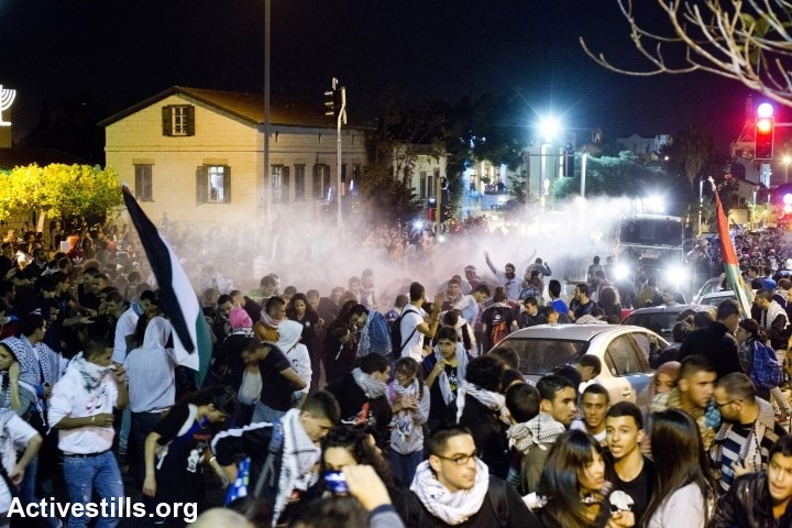 Demonstrators run away from a police water canon track during a Day Of Rage protest against the Prawer-Begin Plan, Haifa, Israel, November 30, 2013 (Photo: Activestills)