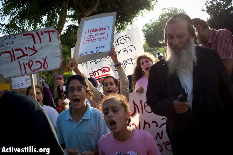 Members of the Shabi family and activists protest for public housing and to show solidarity with the Shabi family, which was evicted from her house and now lives in a park, in the city of Petach Tikva, July 23, 2013 (Photo: Activestills)