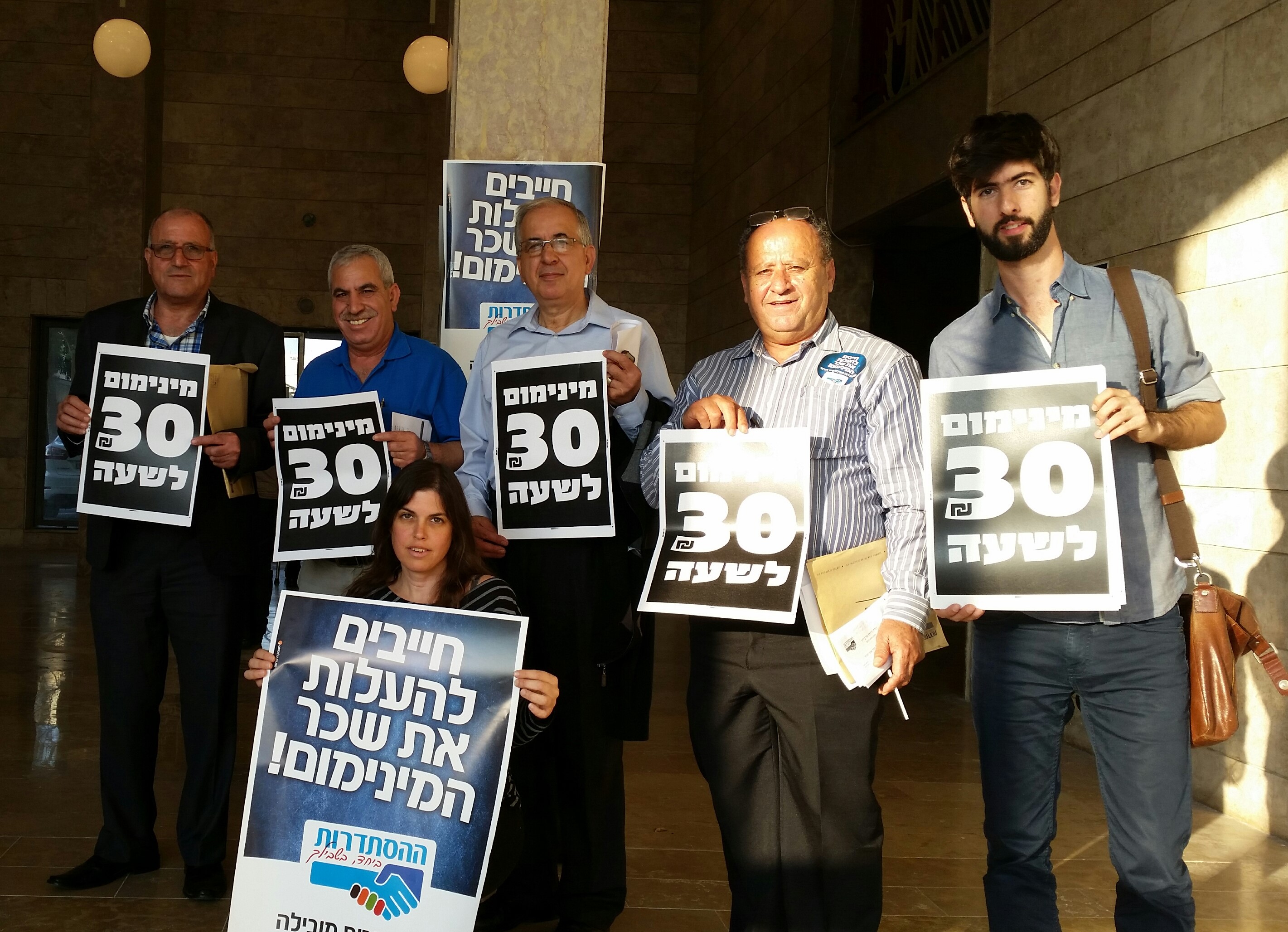 Hadash fraction members at the Histadrut headquarters in Tel-Aviv on Tuesday demanding to raise the minimum wage to 30 NIS an hour  (Photo: Hadash) 