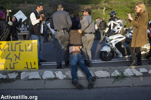 Israeli police drag away a protester as activists block the Ayalon Highway during the eviction of the 8 families from their homes in the Givat Amal neighborhood, Tel Aviv, December 29, 2014.