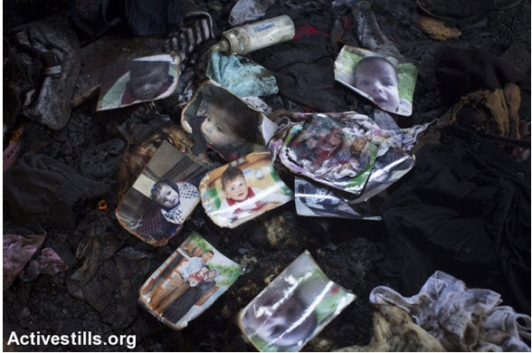 Photos of 18-month-old Palestinian toddler Ali Saad Dawabsha who died when his family’s home was set ablaze by Jewish settlers in the West Bank village of Duma, lie on the ground of the burnt house, July 31, 2015.