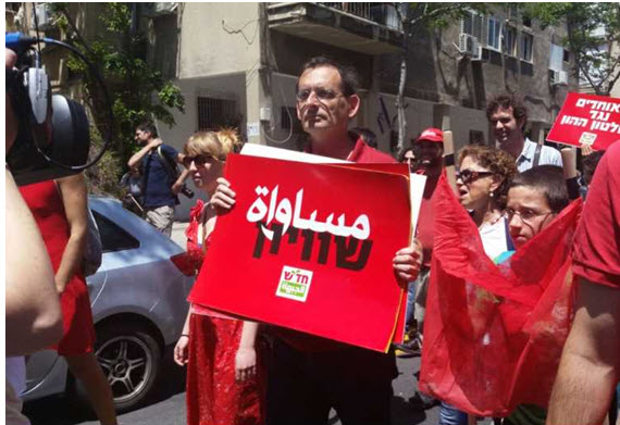 MK Dov Khenin during this past year’s May Day parade in Tel Aviv with the Hadash banner calling for "Equality" in Hebrew and Arabic
