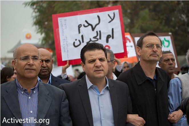 Hadash MKs from the Joint List, Ayman Odeh (center) and Dov Khenin (right), taking part in the march to the Be’er Sheva District Courthouse, to protest against the planned demolition of Umm al-Hiran and Atir, March 3, 2016. The sign in the background reads in Arabic: “No to the destruction of Umm al-Hiran.”