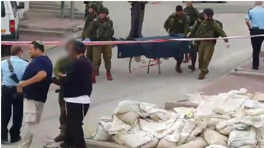 Israeli soldiers removing the corpse of Abd al-Fatah al-Sharif from the scene of his extrajudicial execution, Hebron, March 24, 2016