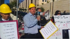 MK Aiman Odeh (Hadash) head of the Joint List addresses protestors from the Hadash faction in the Histadrut during a demonstration outside the Ministry for the Economy demanding the resignation of the minister in charge - Prime Minister Benjamin Netanyahu - following the government's inaction in combating work-related accidents, particularly in the construction sector, February 8, 2016.
