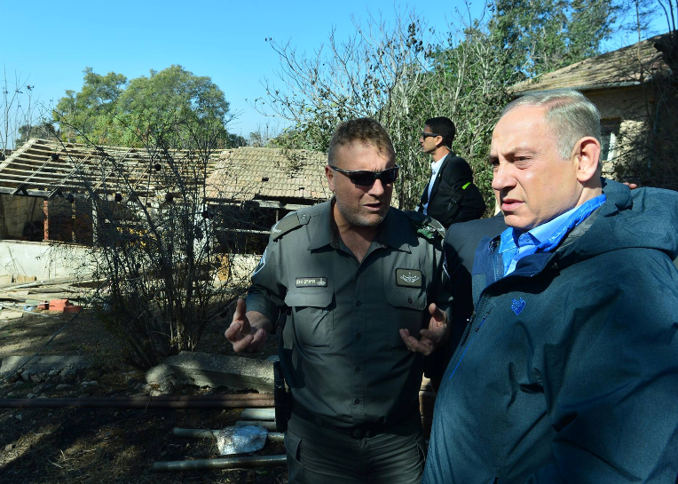 Prime Minister Benjamin Netanyahu with a Border Police officer at the scene of one of the fires after it was extinguished