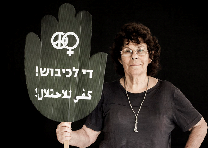 Edna Zaretzky Toledano, one of the founders of Women in Black and former Hadash member of the Haifa City Council, holds a placard reading “Enough Occupation!” in Hebrew and Arabic.