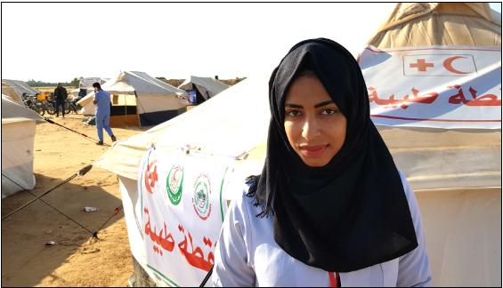 Rula a-Najar, 20, a nursing student from Khuza’ah and volunteer with a non-profit organization that provides medical care stands in front of a clinic tent not far from the Gaza border.
