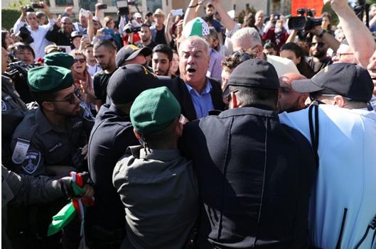 Israeli police accost the chairman of the High-Follow Up Committee for the Arab Citizens of Israel, former Hadash MK Muhammad Barakeh, during Monday’s protest in Jerusalem.