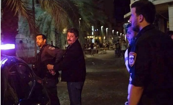 Jafar Farah, chairman of the Mossawa human rights group, being led away in handcuffs and walking on his own, still apparently uninjured, Friday night, May 18