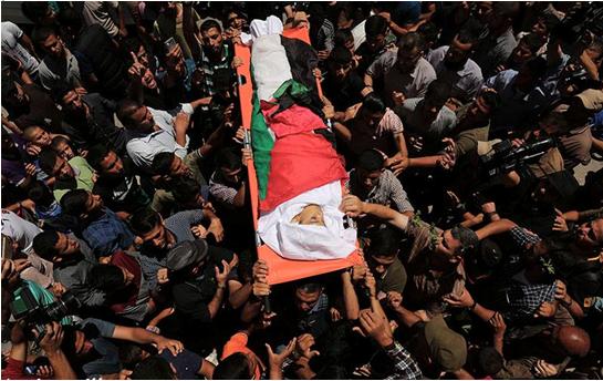 Yasser Abu al-Najja, 14, is brought to burial in Khan Yunis in the southern Gaza Strip, June 30, 2018. The youth was killed Friday by a bullet to the head fired by an Israeli sniper during a protest calling for the right of return and end to the siege of Gaza.