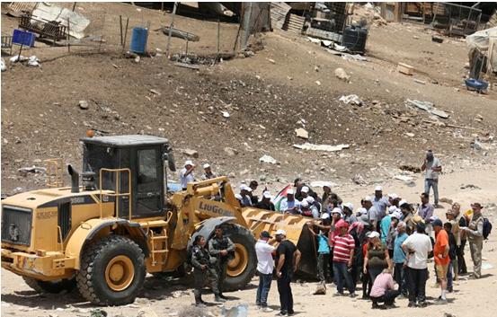 Protesters stand in path of a bulldozer near Khan al-Ahmar, on Wednesday, July 4.