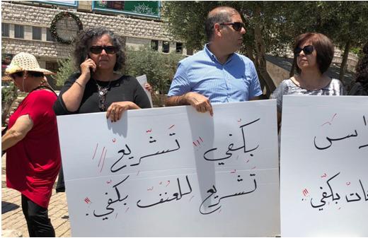 MK Aida Touma-Sliman (second from left, in black) during a demonstration held in Nazareth to protest violence against the murder of women, May 17, 2018; the sign she’s holding reads: “Enough religious mandating of violence.”