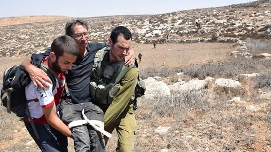 An activist from Ta'ayush being evacuated to hospital after the brutal attack by settlers at the Mitzpe Yair outpost, Saturday, August 25, 2018