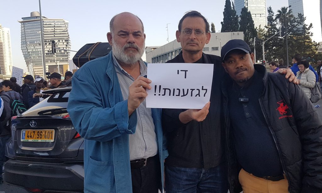 Hadash deputy chairman Dr. Efraim Davidi, MK Dov Khenin and A.D., a social activist during Wednesday's demonstration against racism in Tel Aviv; the sign held by Davidi reads "Enough of racism!!"