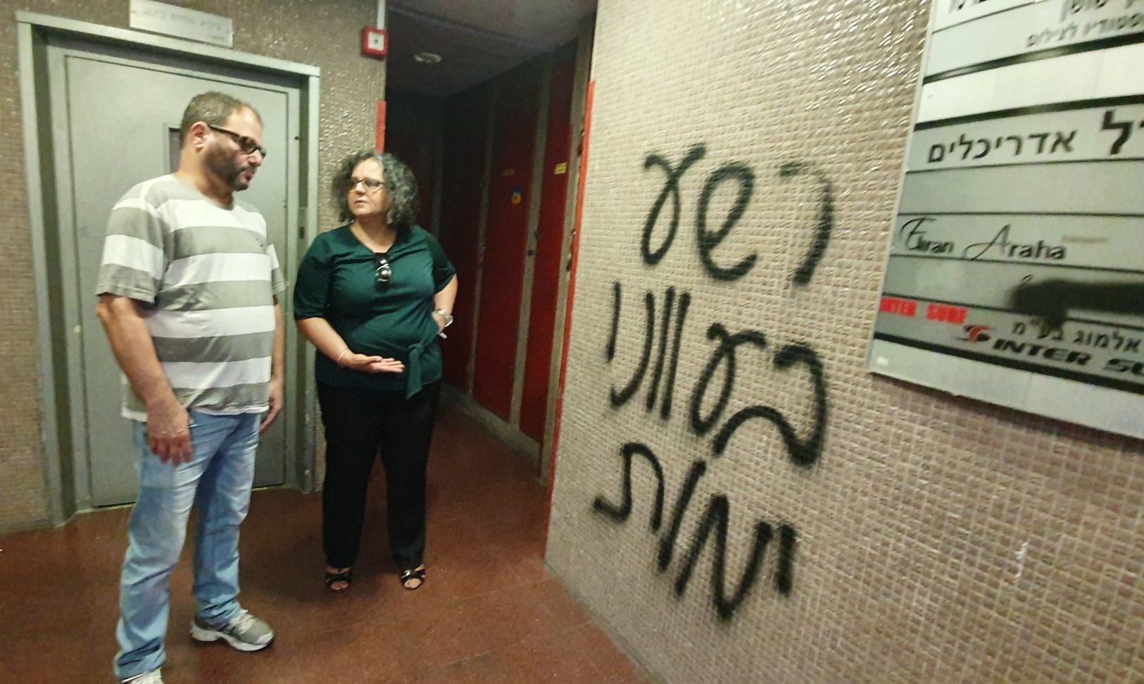 Hadash MKs Cassif and Touma-Sliman near the death threats sprayed in Tel Aviv outside the offices of Amnesty International; the Hebrew graffiti reads: "An evil one will die in his sin."