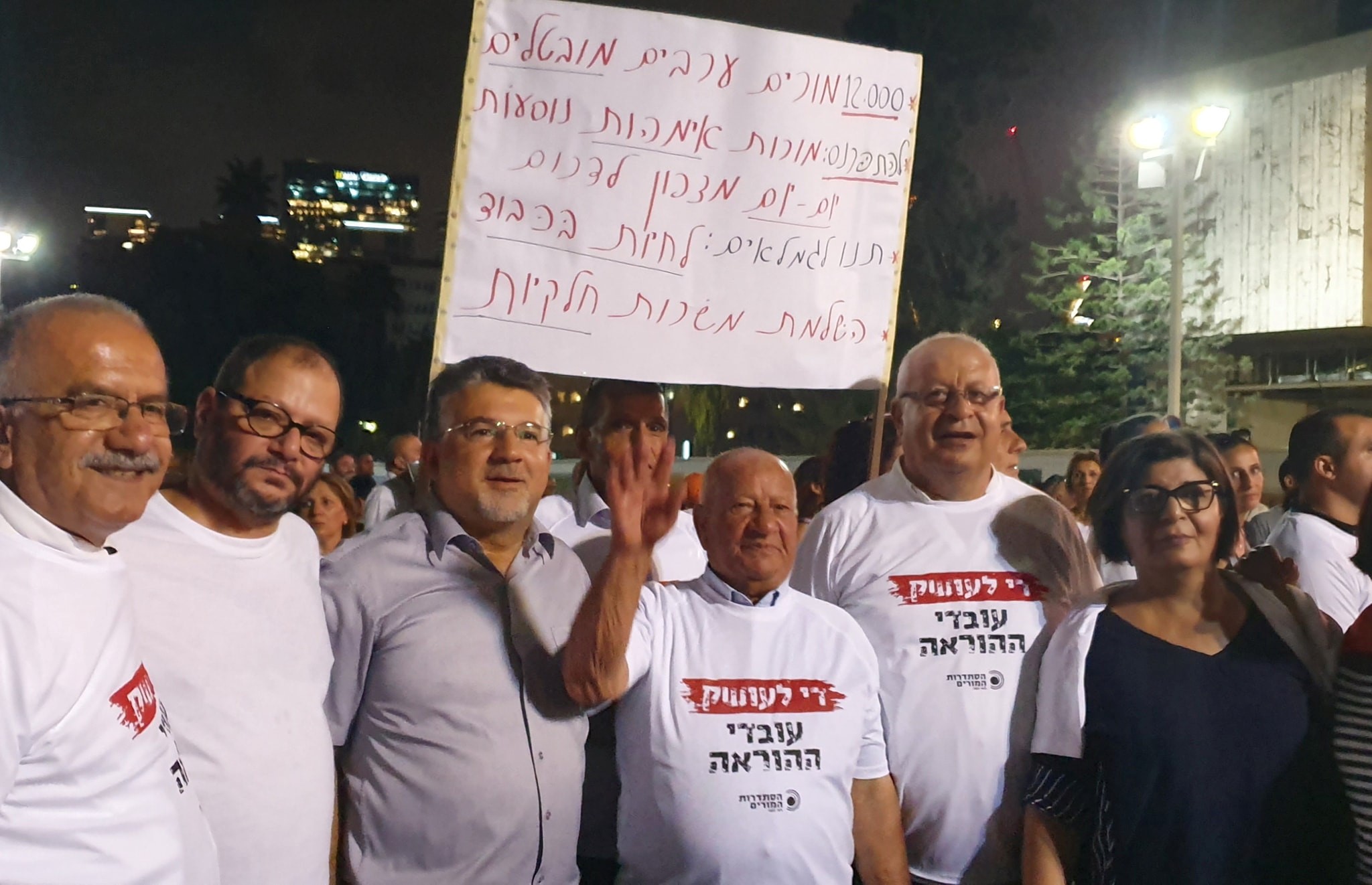 Hadash MKs Ofer Cassif and Youssef Jabareen (second and third from left) and Teacher's Union activists from Hadash during the demonstration held in Tel Aviv, last Thursday night, August 29; the sign reads: "*12,000 unemployed Arab teachers; *To earn a living, teachers who are mothers travel daily from the north to the south; *Let pensioners live with honor; *Make part-time jobs full-time."