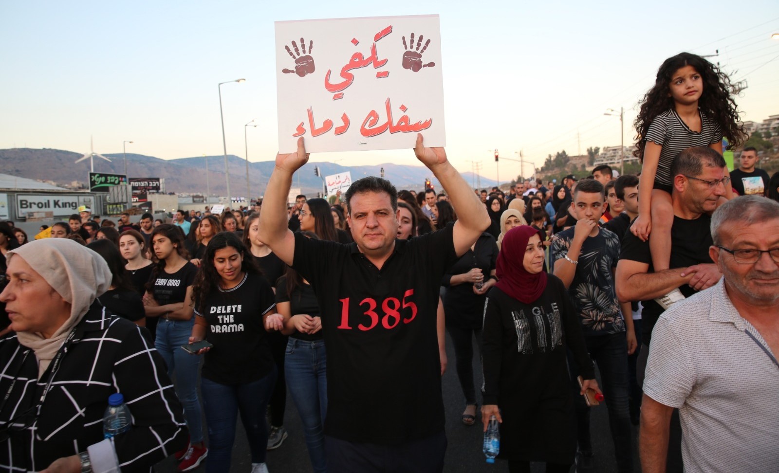 MK Ayman Odeh during the demonstration against violence, last Tuesday in Majd al-Krum; the sign he's holding aloft reads "Enough bloodshed." The number 1385 on his shirt is the toll of Arab citizens of Israel who have died since the year 2000 as a result of violence.