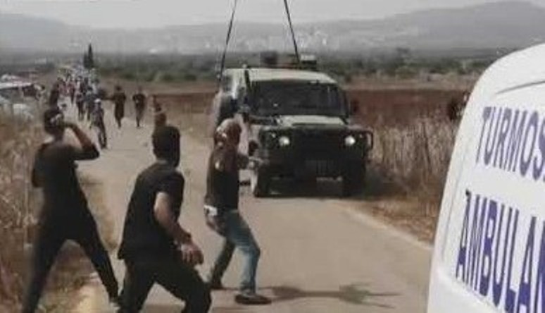 Following the Israel army's violent suppression of the initially peaceful protest near Turmus Ayya on Thursday, October 17, Palestinians hurl stones at a military jeep.