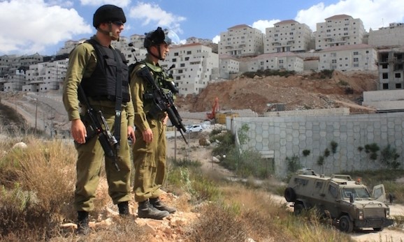 Occupation soldiers standing on the periphery of the West Bank settlement of Beitar Illit, which was partially built on land expropriated from the Palestinian village of Wadi Fukin