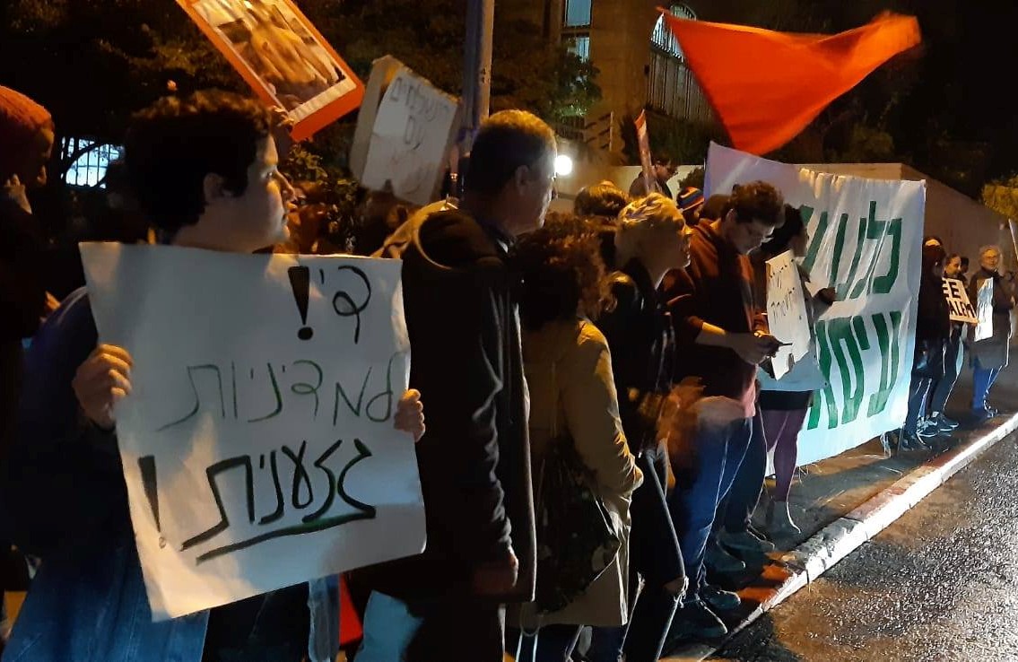 Hundreds of Israeli and Palestinian activists demonstrate close to Prime Minister Benjamin Netanyahu's official residence on Saturday night, December 7, in solidarity with the residents of Issawiya. The large banner beneath red flag in the right of the photograph reads: “We are all with Issawiya”; the placard to the left proclaims: "Enough of the racist policy."