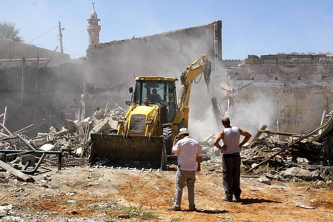 A bulldozer, commissioned by the Israel Land Administration demolishes the foundations of the Adassi family's home in Ajami, an Arab neighborhood in Jaffa.