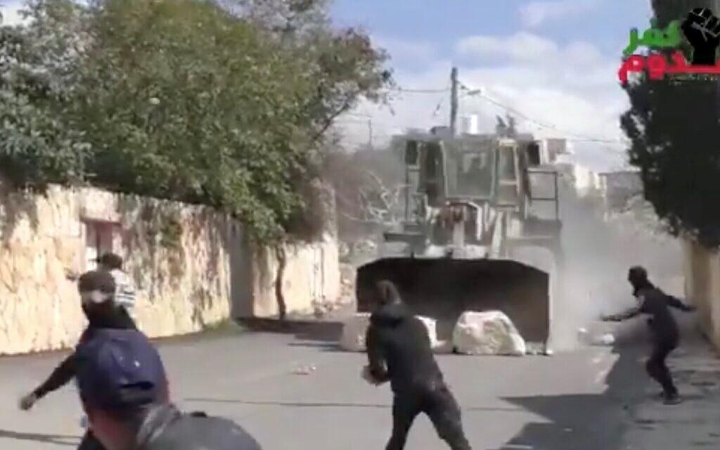 An armored Israeli military bulldozer pushes massive slabs of stone at speed towards Palestinian protesters in Kafr Qaddum, near Qalqilia in the occupied West Bank. Friday, February 21.
