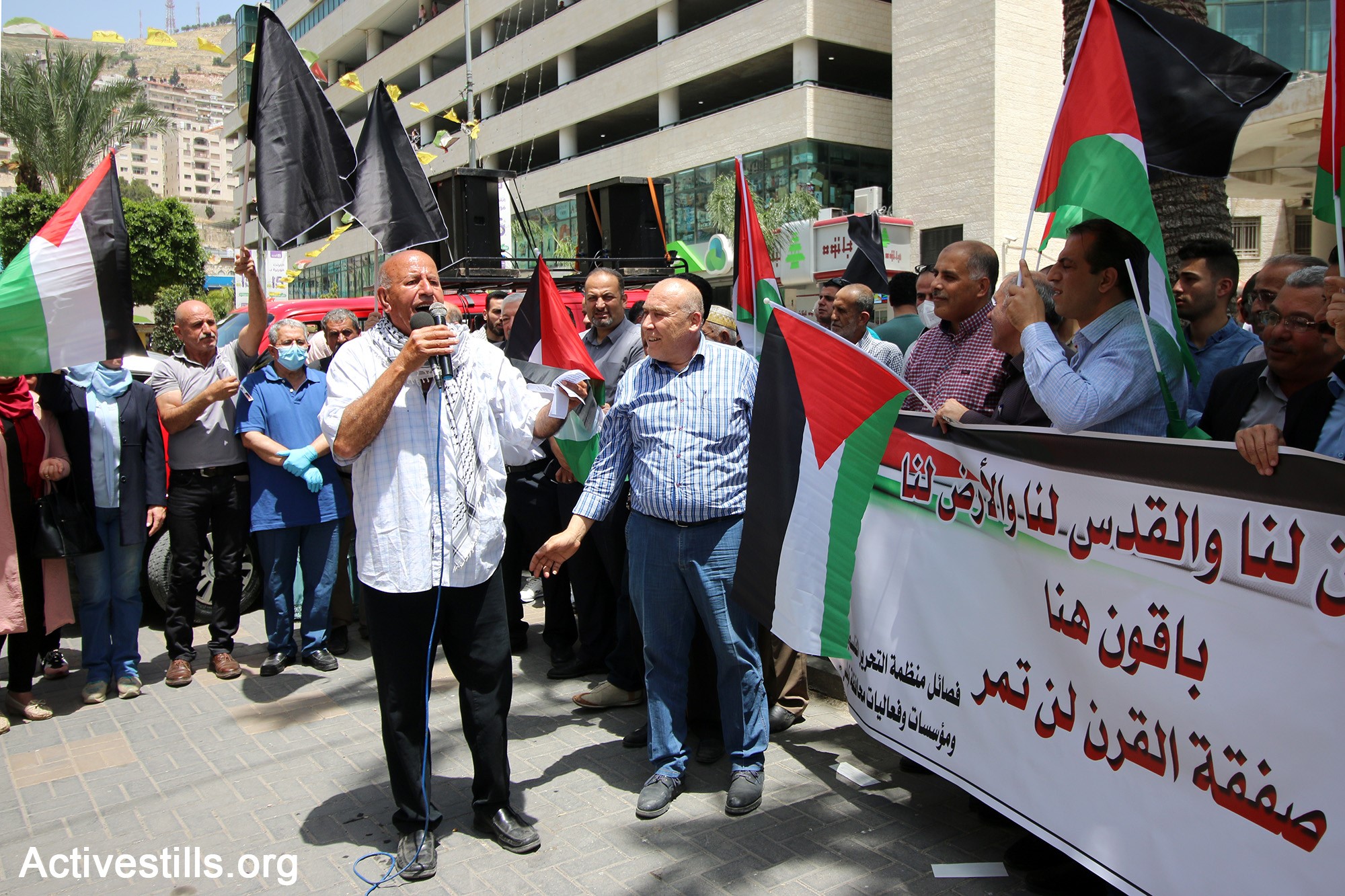 Palestinians protest in Nablus against Israel's plans to annex parts of the occupied West Ban, May 14, 2020. The large banner reads, in part "… Jerusalem is ours and the land is ours; [We are ] staying here; the [US-Israeli] 'Deal of the Century' will not pass."