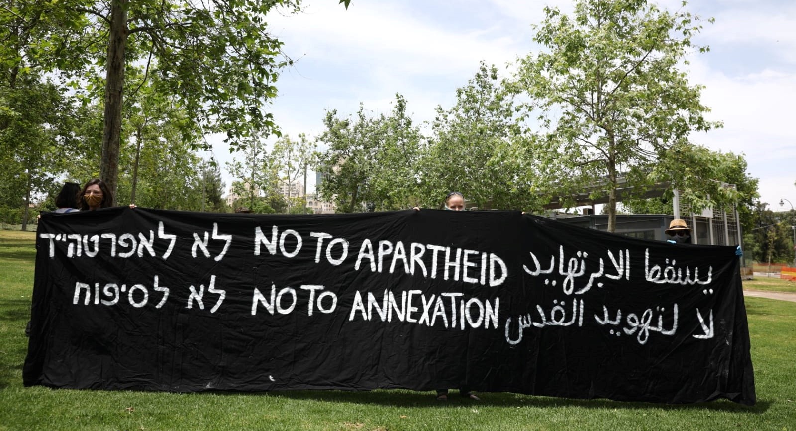 Demonstrators hold a vigil against annexation opposite the US Consulate in West Jerusalem, May 16, 2020. The Hebrew and English slogans are the same; in Arabic the messages are "Apartheid will fall" and "No to the Judaizing of Jerusalem."