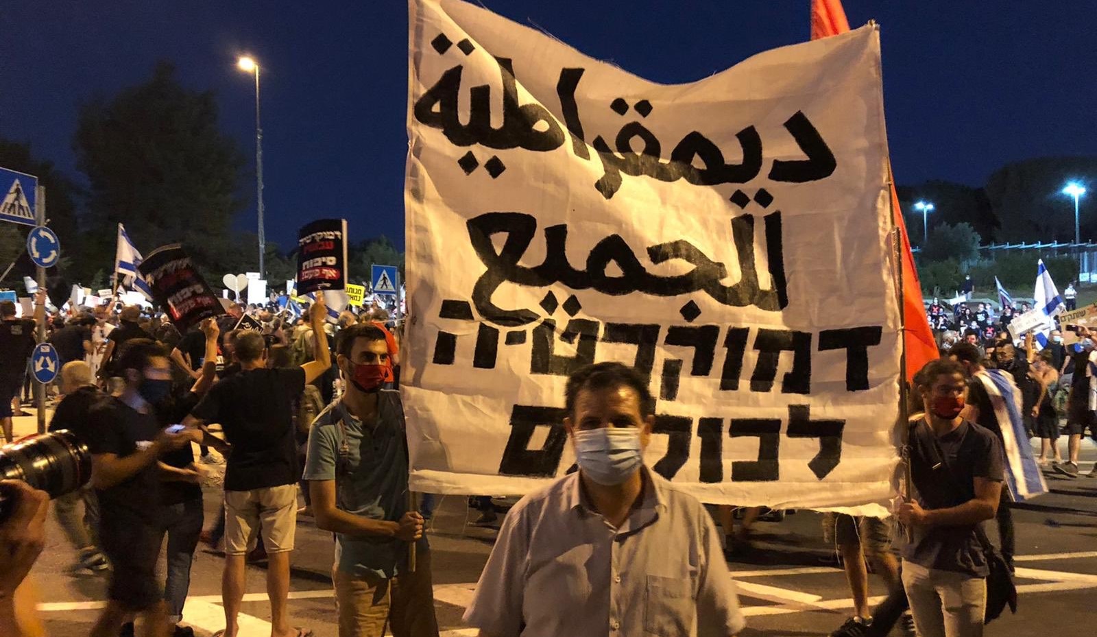 Joint List leader, MK Ayman Odeh, during the Jerusalem demonstration against Prime Minister Netanyahu on Tuesday, July 21, 2020. The banner in Arabic and Hebrew reads "Democracy for all."