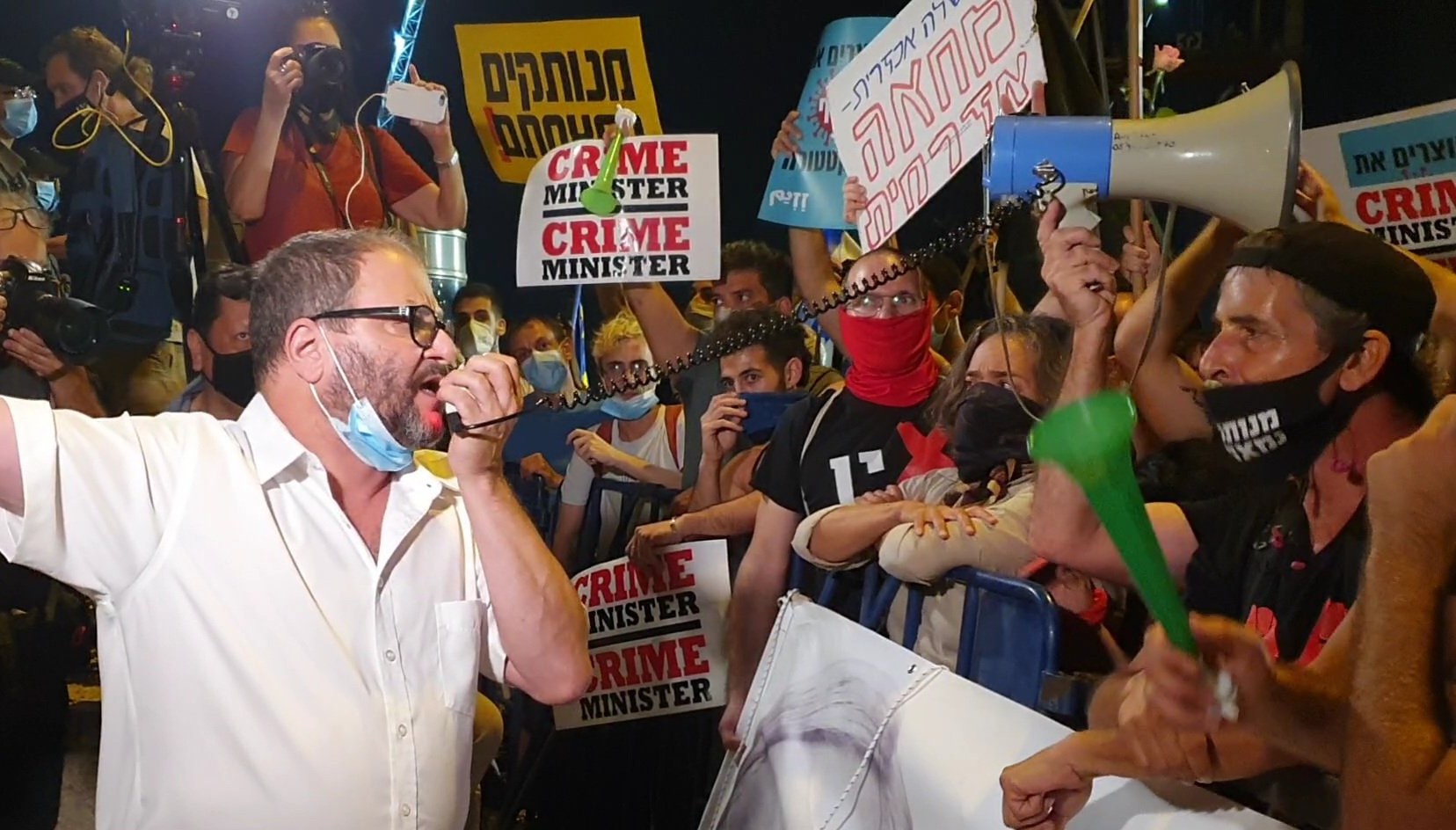 Joint List MK Ofer Cassif (Hadash) addresses demonstrators protesting against Prime Minister Netanyahu in Jerusalem on Tuesday, July 21.