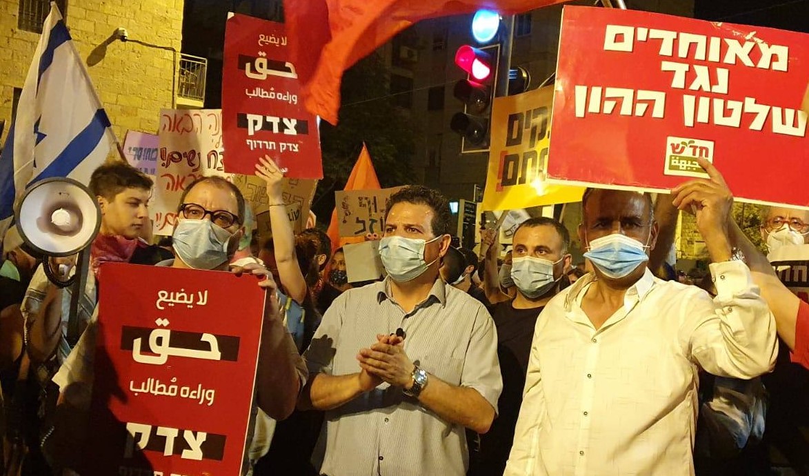 MKs Ofer Cassif (left) and Ayman Odeh (center) with Hadash Secretary General Mansour Dahamshe (right) took part in the mass protest held in Jerusalem on Saturday night, July 25, near the Prime Minister's official residence. The Hadash placard held aloft by Dahamshe reads: "United against the rule of capital." Cassif's placard reads, "Justice, justice shall thou pursue [Deuteronomy 16:20].