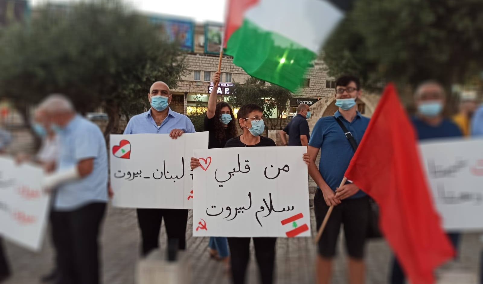 Members of the CPI hold a vigil in Nazareth in solidarity with the victims of the Beirut port explosion, Tuesday, August 4, 2020. The sign in the center reads: "Peace for Beirut, from my heart." The sign to the left of the first reads "Lebanon – Beirut."