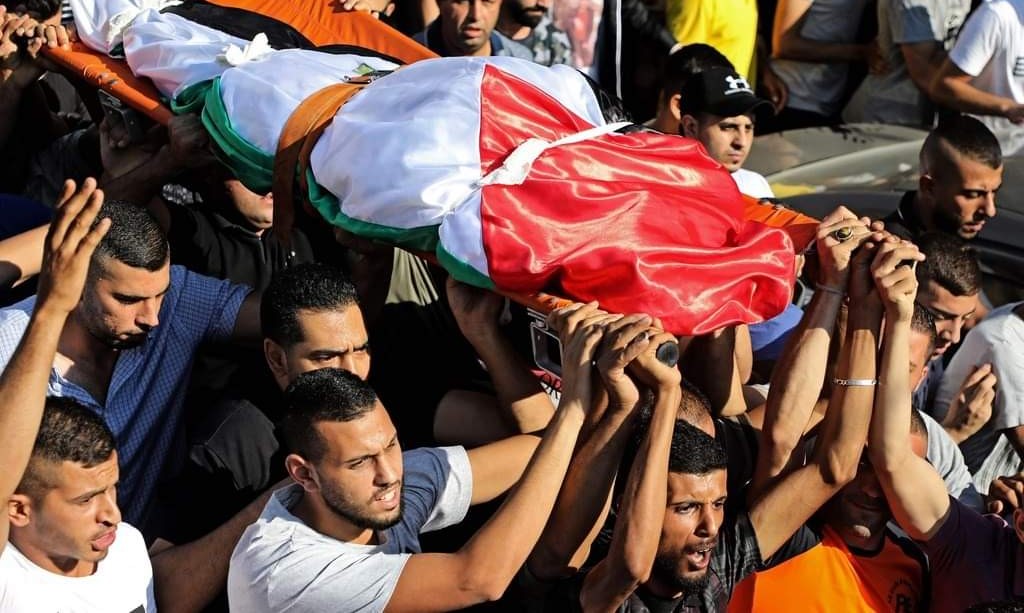 The body of 23-year-old Dalia Samoudi, shrouded in a Palestinian flag, is brought to burial on Friday, August 7, in the Palestinian city of Jenin in the northern West Bank.