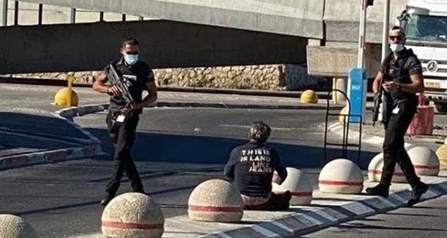 Israeli private security contractors move in on a 60-year-old deaf Palestinian after shooting and wounding him on Monday, August 17, at Qalandiya checkpoint near Jerusalem.