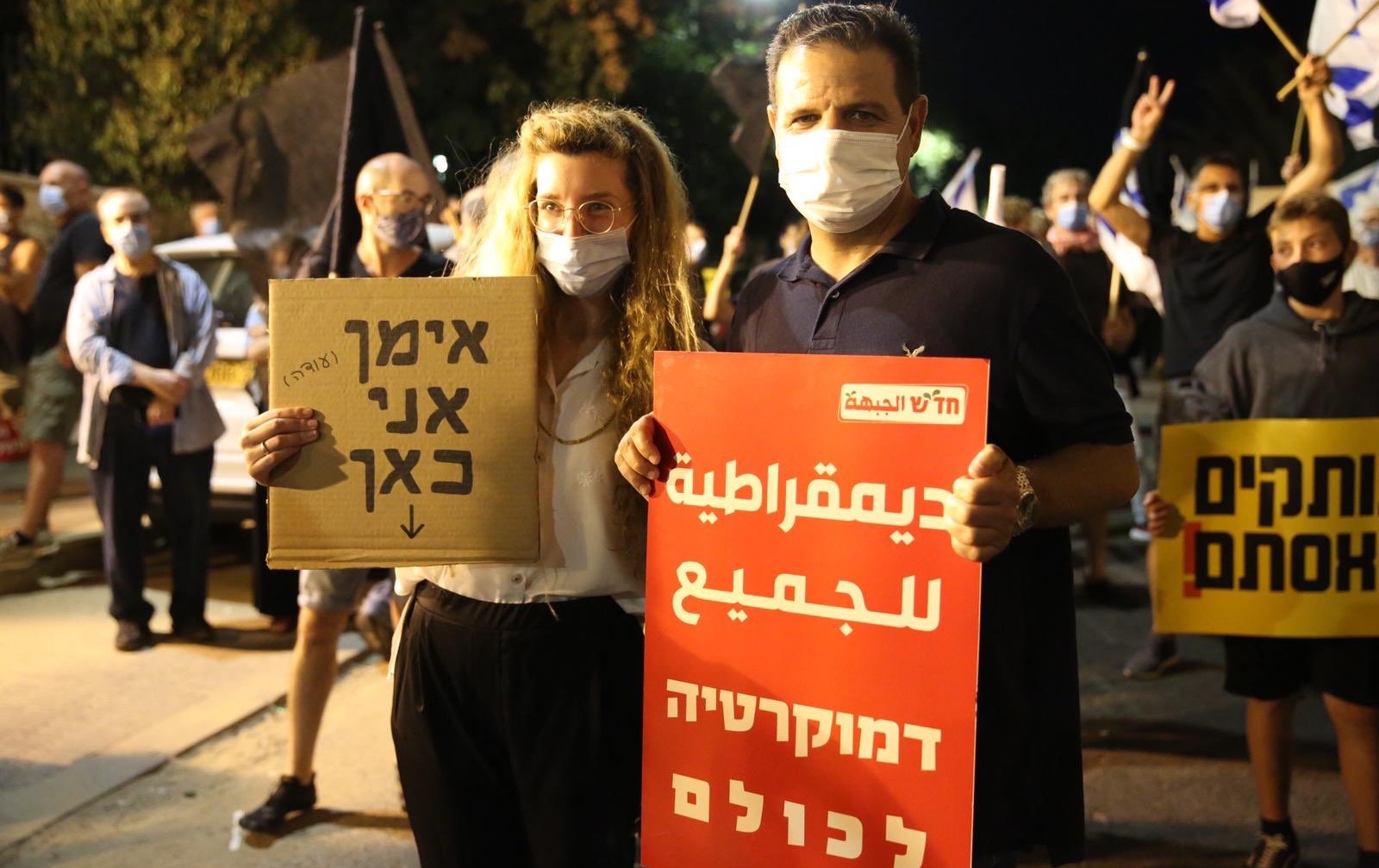 MK Ayman Odeh holds a Hadash placard that reads in Arabic and Hebrew "Democracy for all" during the anti-government protest in Paris Square, near the PM’s official residence, on Saturday night, August 22. The women protester next to Odeh holds a sign in Hebrew reading "Ayman, I'm here."
