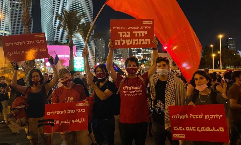 Young communists are among the hundreds who blocked Begin Road in Tel Aviv, Thursday evening, August 27. The Hadash placard held aloft in the center of the picture reads: "Salaried workers, independents and unemployed together against the government." The Hebrew-Arabic signs read "Bibi / Netanyahu is good for the rich."