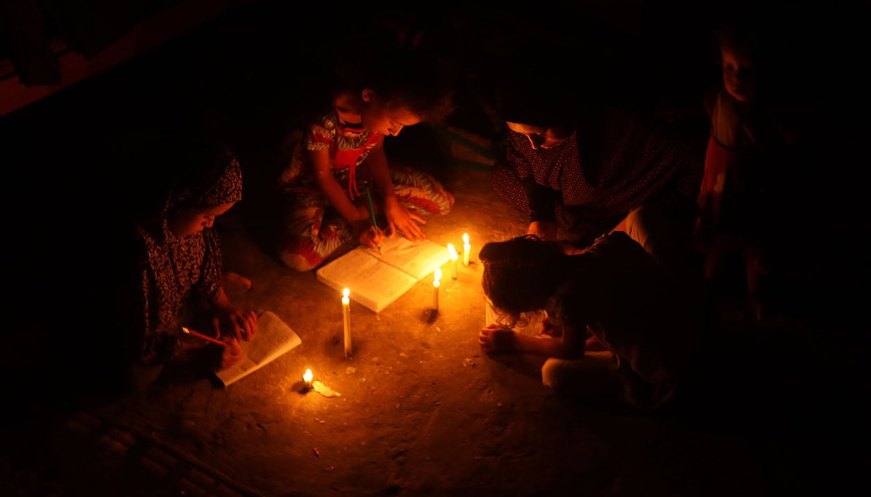 Palestinian children use candles to do their homework in an impoverished household in Khan Yunis in the southern Gaza Strip. 