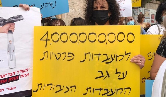 Public lab workers demonstrate outside of the Prime Minister's official residence in Jerusalem on the third day of their strike, Tuesday, September 1. The placard reads "4 billion [shekels] to private laboratories on the backs of the public labs."