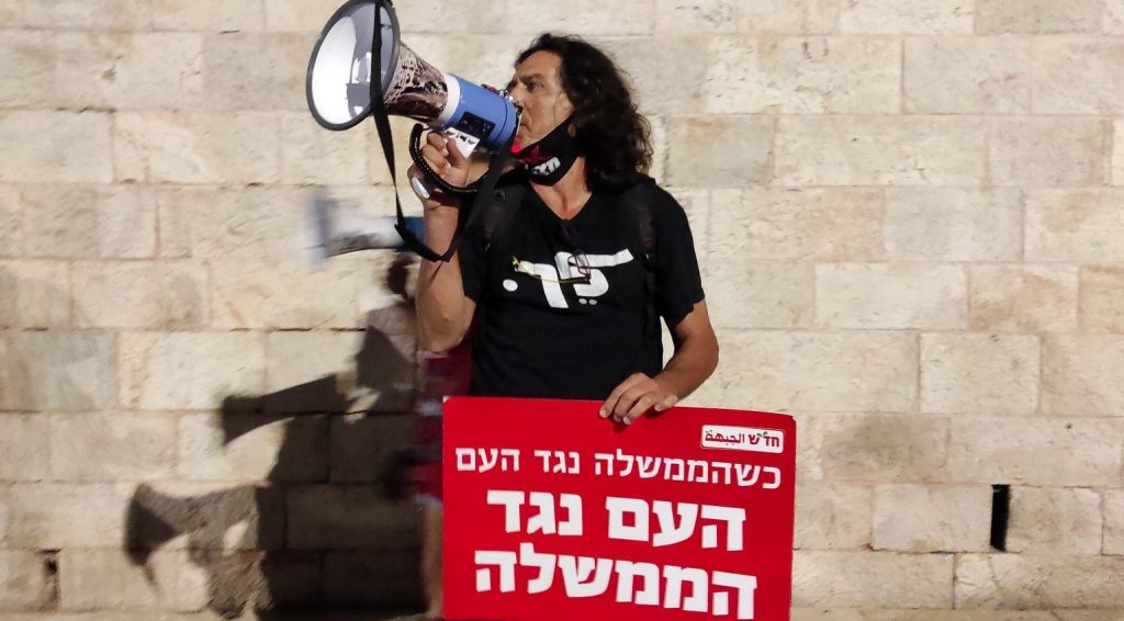 Leading protest activist Sadi Ben-Shitrit at the demonstration at Jerusalem’s Paris Square Wednesday evening, September 30, near the official residence of Prime Minister Benjamin Netanyahu whose resignation the protestors called for. The red Hadash placard reads” When the government is against the people, the people are against the government.”