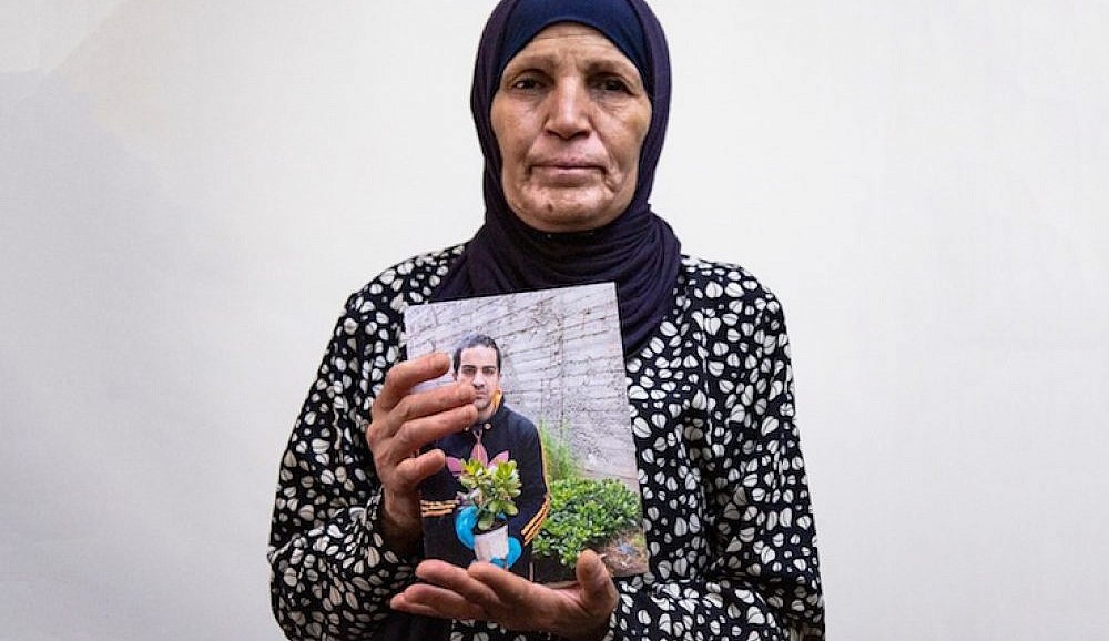 Ranah al-Hallaq, the mother of Iyad, the Palestinian man with autism who was killed by a Border Police officer, holds up a photo of her son, June 2, 2020.