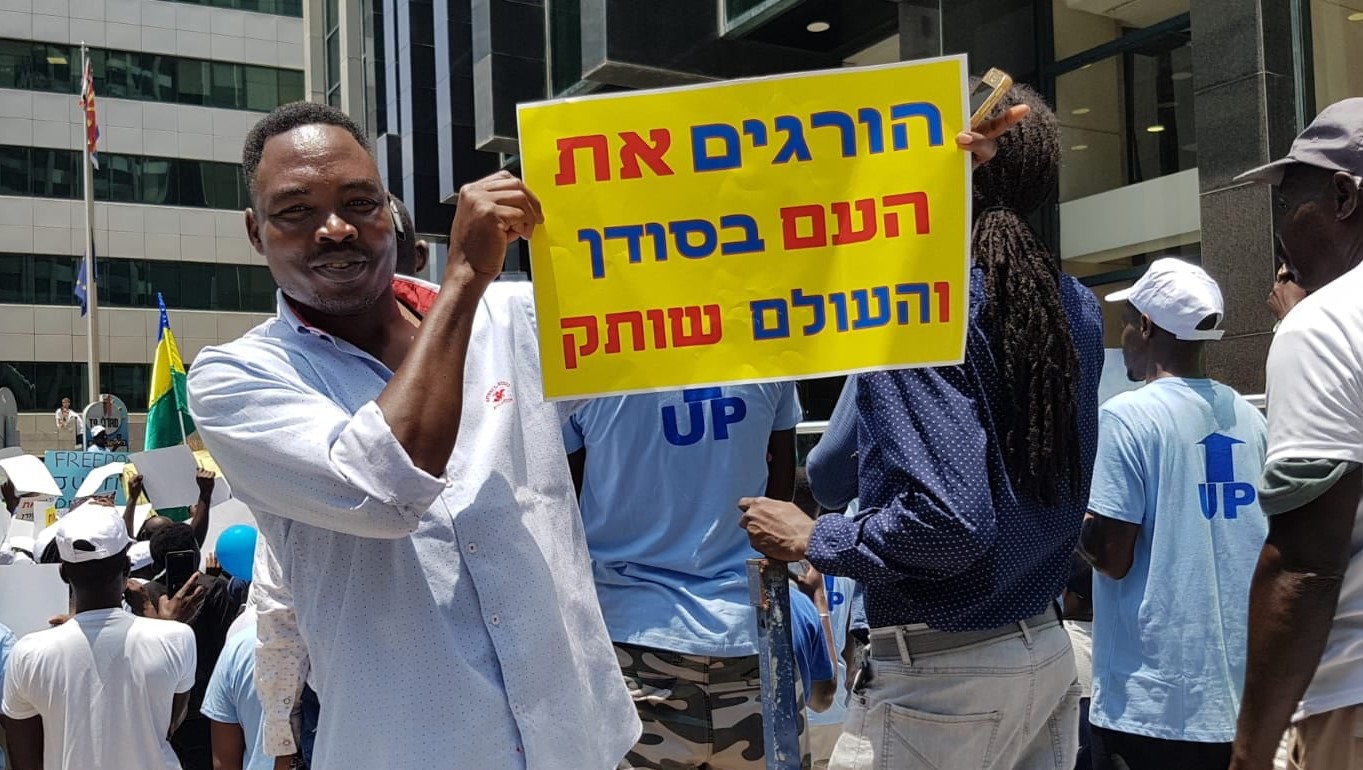 Sudanese asylum-seekers demonstrate in Tel Aviv in solidarity with the popular ongoing struggle for democracy in their country, June 2019. The sign in Hebrew held aloft reads “They're killing the people in Sudan and the world remains silent.”
