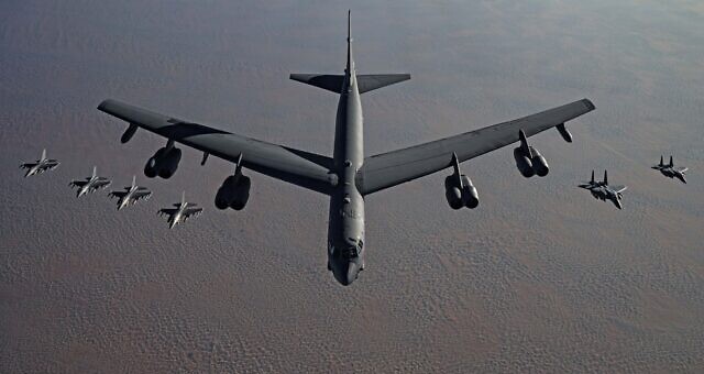A B-52 heavy bomber, flanked by fighter jets, flies to the Middle East in a tacit threat to Iran on November 21, 2020