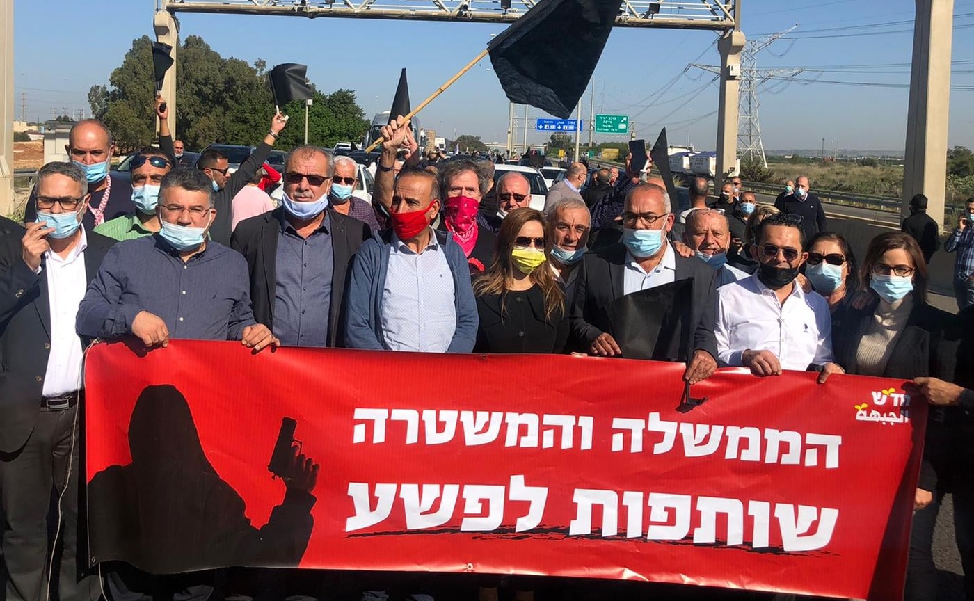 Leading members of the Joint List, including Hadash MK Youssef Jabareen (second from left) and the chair of the High Follow-Up Committee for Arab Citizens of Israel, Mohammed Barakeh (third from left), are among the hundreds who blocked traffic for about an hour on Route 6, Monday, December 21, to protest government and police inactivity in eliminating violent crime in Israel's Arab communities. The Hasash poster reads in Hebrew: "The government and police are complicit in the crime."