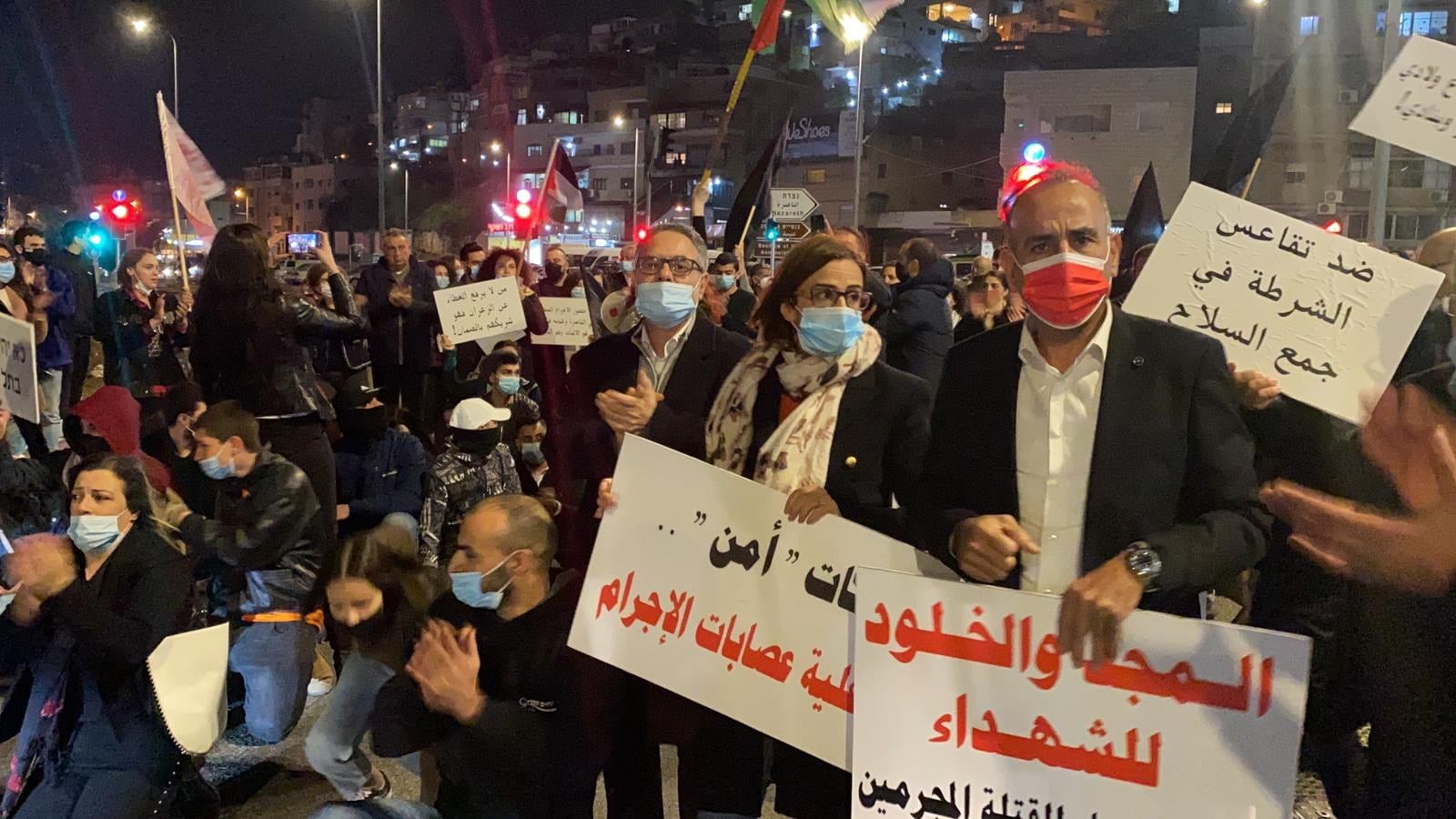 Hundreds block the entrance to Nazareth on Friday night, February 5, 2021. First from right: Hadash secretary, Mansour Dahamshe; next to him are two Joint List MKs from Balad: Heba Yazbak and Mtanes Shehadah; among the placards: "Glory and eternity to the martyrs"; "Against police inaction in collecting arms."