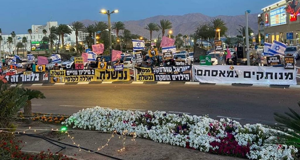 Anti-Netanyahu protesters demonstrate in the southern city of Eilat, near the Red Sea, Saturday evening, March 13, 2021.